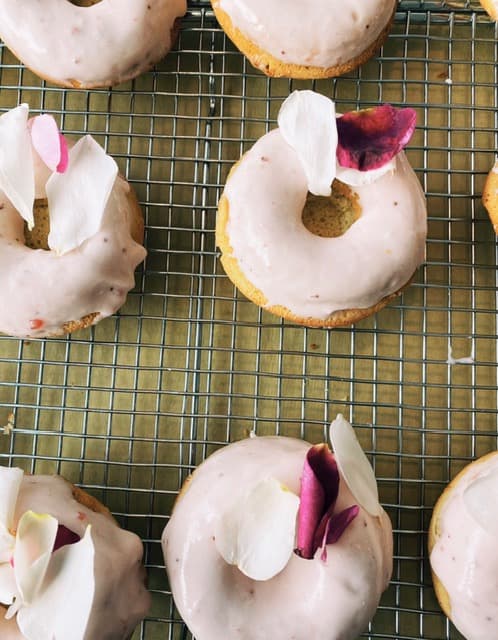 Rose petal glazed baked donuts on a cooling rack
